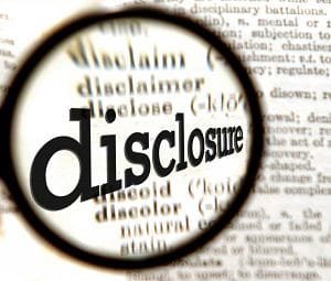 Magnifying glass enlarges the word "Disclose" in a dictionary