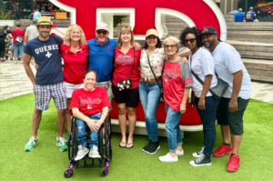 A group of people smiling outside Busch Stadium before a Cardinals game