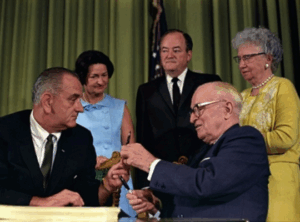President Johnson handing President Truman the pen he used to sign Medicare into law.