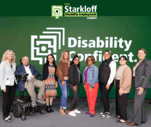 Group of Starkloff staff, board members, and attendees smiling onstage. The background is Starkloff’s Disability Confident logo.