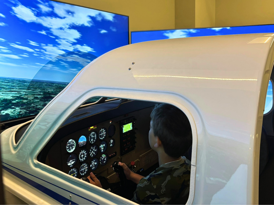 A Dream Big student piloting a small plane in a flight simulator.