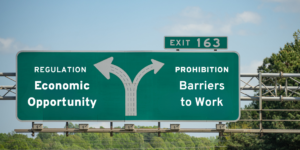 Highway sign showing forked road: one way is Regulation and Economic Opportunity, the other is Prohibition and Barriers to Work.