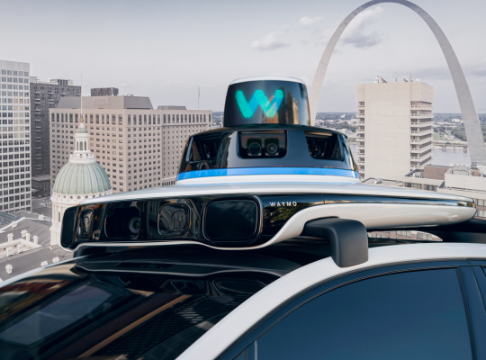 Waymo vehicle in front of St. Louis skyline.