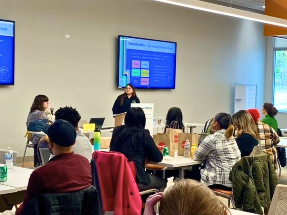 Two adults giving a presentation to a room full of professionals.