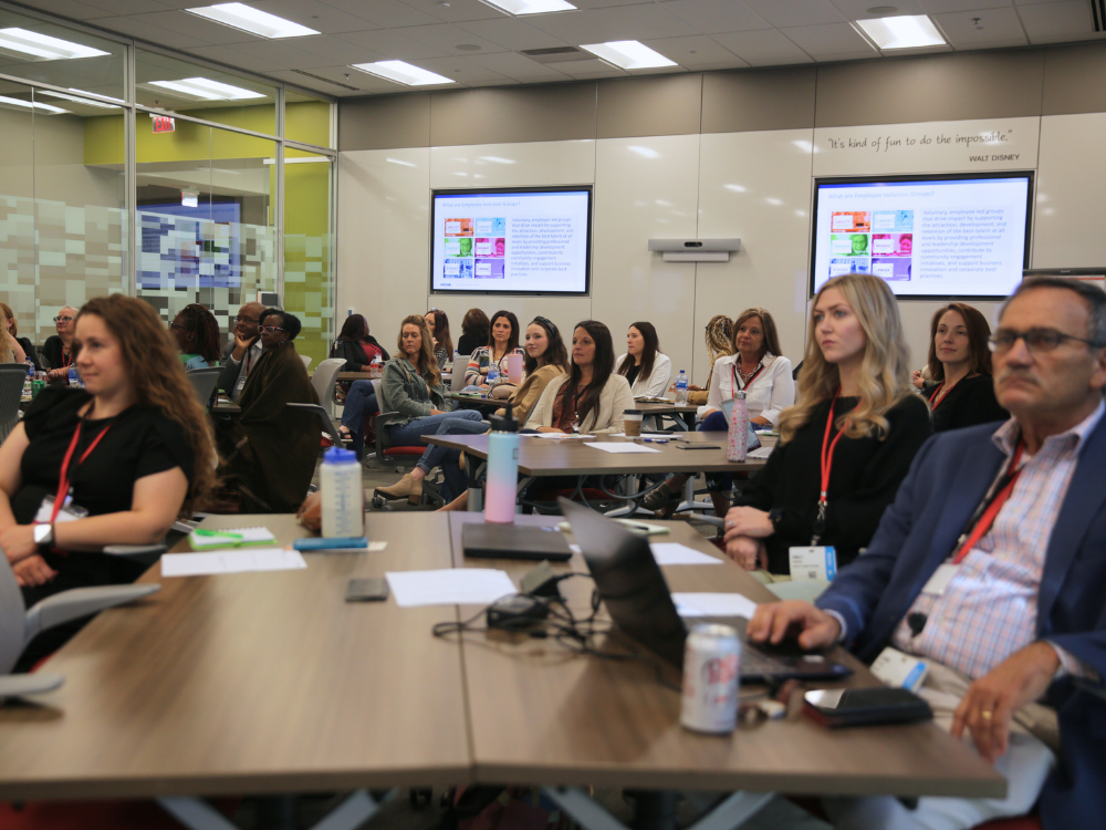 Conference room of professionals listening to presentation.