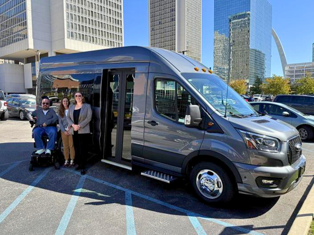 SDI leadership smiles in front of a shiny, new, accessible, high-capacity van.