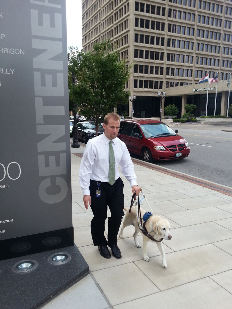 Centene employee walking with his guide dog Centene employee walking with his service dog outside of their office in downtown Clayton, MO.