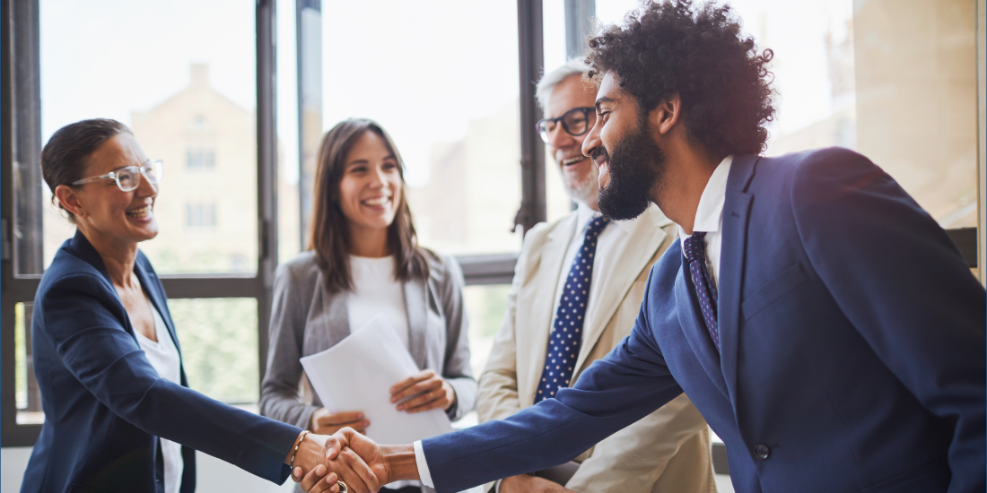 Career success for a new employee warmly welcomed in corporate workplace.