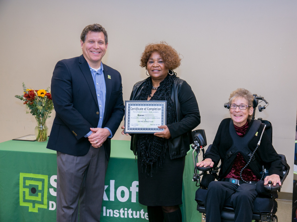 Starkloff Career Academy graduation. SDI board member, Career Academy graduate, and program leader Susan Menhard pose together while the graduate holds a framed certificate.